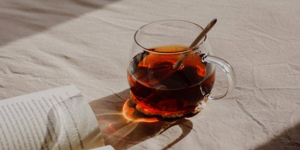 teh hitam di dalam gelas di atas kasur