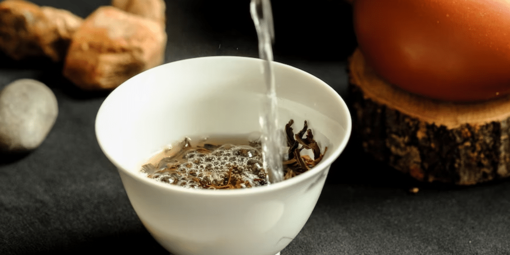 Menuang air panas ke cangkir berisi teh